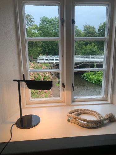 a desk with a window and a lamp next to it at The Mill House - Saeby Watermill in Sæby