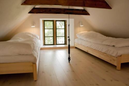 a bedroom with two beds and a window at The Mill House - Saeby Watermill in Sæby