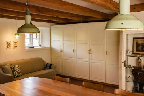a living room with a table and a couch at The Mill House - Saeby Watermill in Sæby
