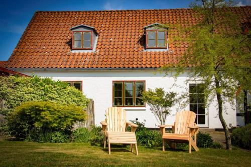 two chairs and a table in front of a house at The Mill House - Saeby Watermill in Sæby