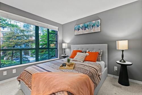 a bedroom with a bed and a large window at Stunning 3 Bed Duplex in Yaletown w Fireplace in Vancouver