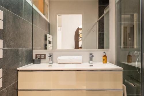 une salle de bain avec un lavabo et un miroir dans l'établissement Bright 2bedroom apartment 15min walk to the Palais, à Cannes