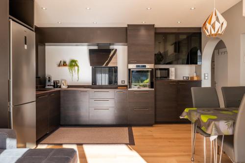 une cuisine avec des appareils en acier inoxydable et une table dans l'établissement Bright 2bedroom apartment 15min walk to the Palais, à Cannes