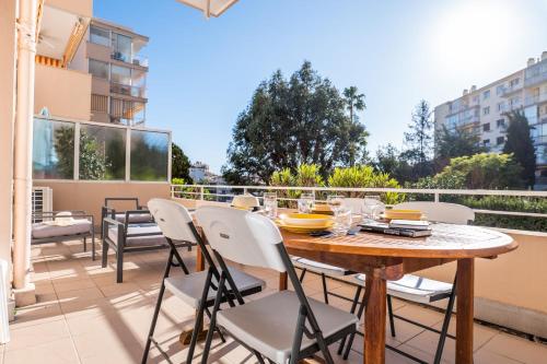 d'une terrasse avec une table et des chaises en bois sur un balcon. dans l'établissement Bright 2bedroom apartment 15min walk to the Palais, à Cannes