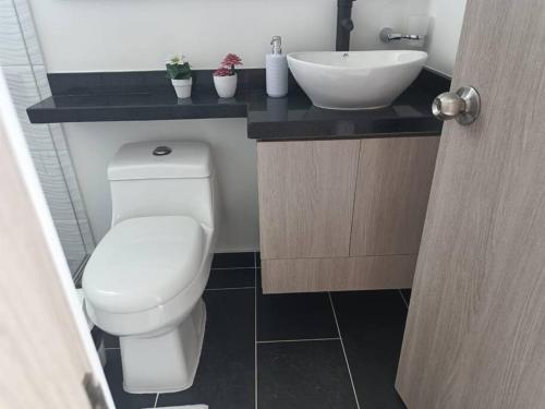 a bathroom with a white toilet and a sink at Espectacular Apartamento en Puerto Azul Club House in Ricaurte