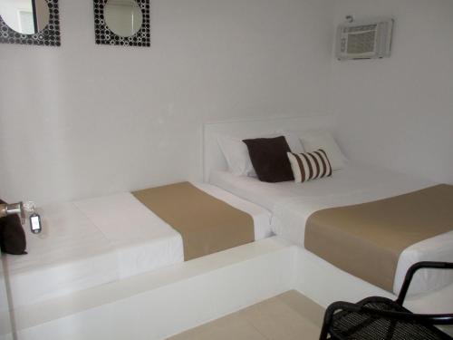 a white room with two beds in it at Rincón del mar Veleros Hotel in San Onofre