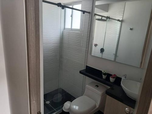 a bathroom with a toilet and a sink and a mirror at Espectacular Apartamento en Puerto Azul Club House in Ricaurte