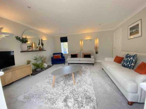 a living room with a white couch and a table at Allt Lwyd - Peaceful & Tranquil Setting in Bangor