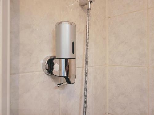 a shower head on the wall of a bathroom at Cosy Case between Disney and Paris in Champs-Sur-Marne