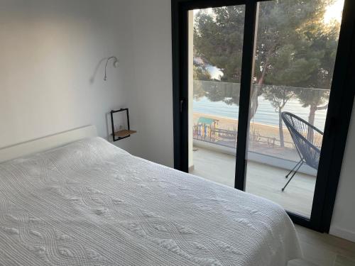 Schlafzimmer mit einem Bett und Strandblick in der Unterkunft Veuràs el Mar - Madrague Beach apartment 15 in Roses