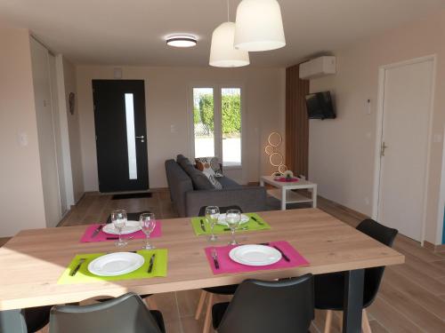 un salon avec une table et des chaises en bois dans l'établissement Superbe Maison individuelle 3ch, 6 pers, jardin, au calme, proche du Lac, 2 Parking, spatieuse et Confortable !, à Saint-Pardoux