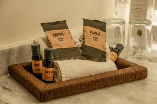 a basket of towels and products on a counter at Hotel Boutique Naura Centro in Oaxaca City