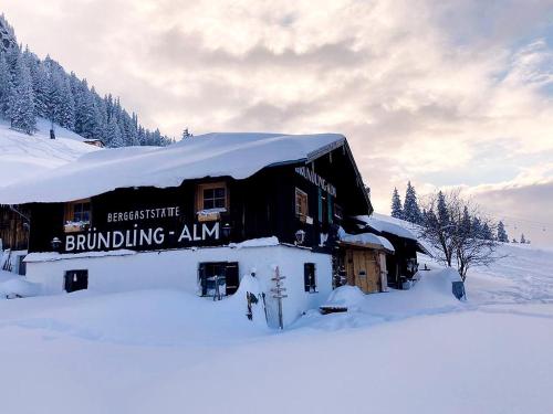 ein Gebäude mit Schnee darüber in der Unterkunft Bründling-Alm Berggasthof auf 1167m auf dem Hochfelln in Bergen