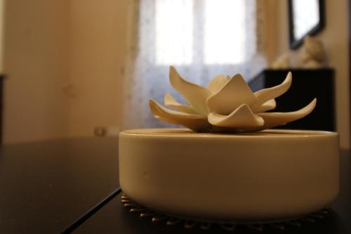 a white cake with a flower on top of a table at Casa 4 Archi in Lentini