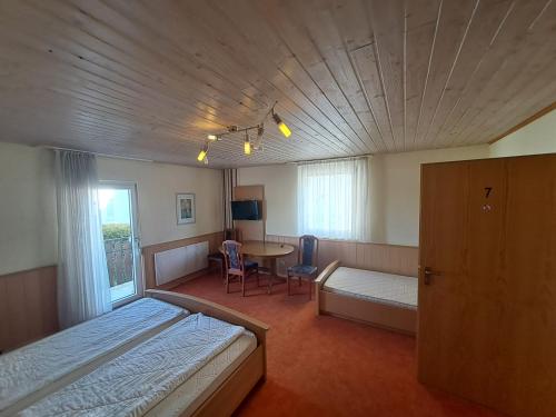 a bedroom with a bed and a table with a tableablish at Gasthof Hirschkeller in Göppingen