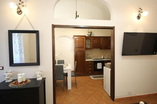 a living room with a mirror and a kitchen at Casa 4 Archi in Lentini