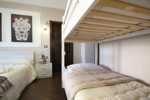 um quarto com 2 camas e uma escada em Casa 4 Archi em Lentini