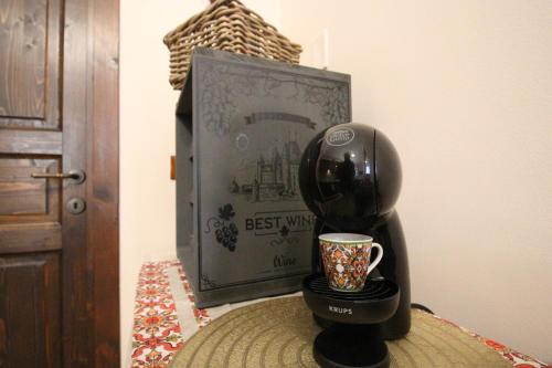 a coffee maker sitting on a table next to a cup at Casa 4 Archi in Lentini