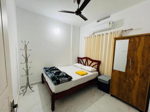 - une petite chambre avec un lit et un ventilateur de plafond dans l'établissement Furnished 2 BHK Family Apartments near Triprayar Shree Rama Temple - Beevees Homes Thriprayar, à Thanniyam
