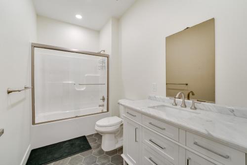 a bathroom with a toilet and a large mirror at St Clair Apartment - Walk to River and Boardwalk! in Marysville