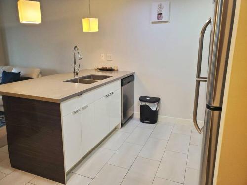 a kitchen with a sink and a refrigerator at Stunning 1 bedroom condo in Calgary with riverview in Calgary