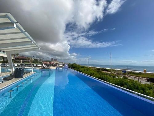 a large swimming pool with a view of the ocean at BALI BEACH HOME CLUB Piçarras in Piçarras