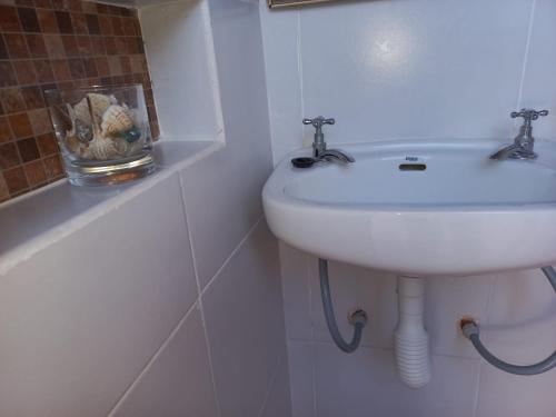 a white bathroom with a sink and a tub at La Evelia in Salta
