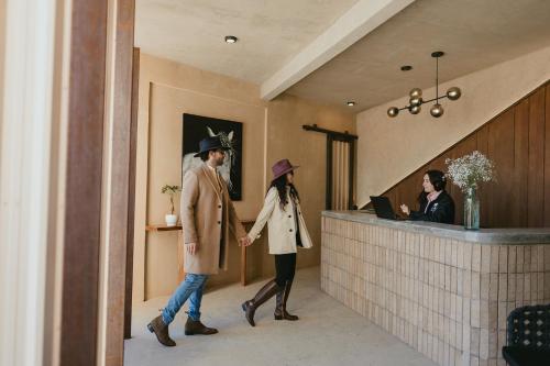 a man and a woman walking through a lobby at Equ Hotel de Tierra in El Porvenir