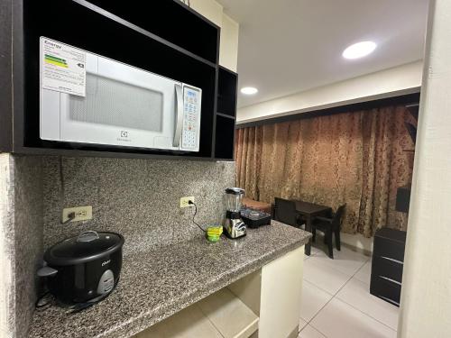 a kitchen with a counter with a microwave above it at Residencia Terreros in Guayaquil