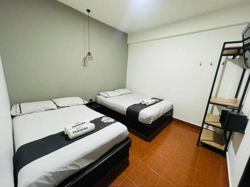 a room with two beds and a ladder in it at Hotel Panorama Medellín in Medellín