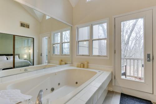 a large white bathroom with a large tub and a bed at East Stroudsburg Townhouse Less Than 1 Mi to Ski Area! in East Stroudsburg