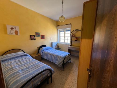two beds in a room with yellow walls at Central House in Castel di Sangro