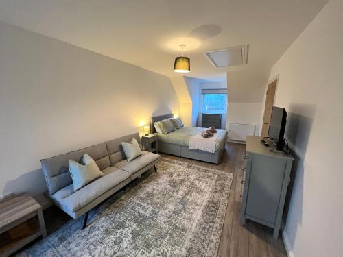 a living room with a couch and a bed at Inchcailloch Townhouse, Loch Lomond in Bonhill