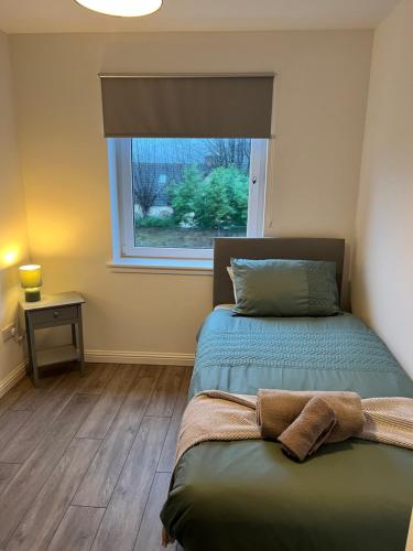 a bedroom with two beds and a window at Inchcailloch Townhouse, Loch Lomond in Bonhill