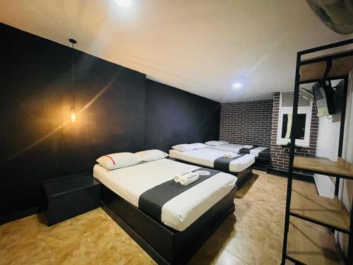 a bedroom with two beds and a television in it at Hotel Panorama Medellín in Medellín