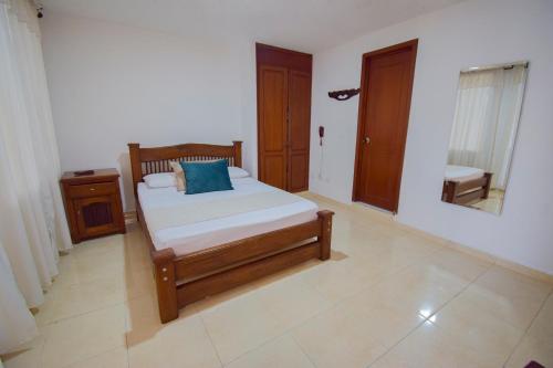 a bedroom with a bed and a mirror in it at Hotel Toledo Plaza in Armenia