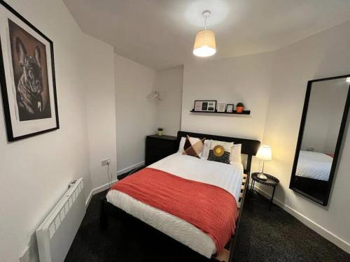 a bedroom with a bed with a red blanket at Boutique 2Bed Apt with Great Amenities in Liverpool