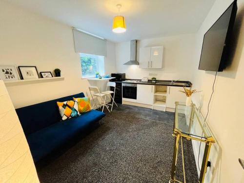 a living room with a blue couch and a kitchen at Boutique 2Bed Apt with Great Amenities in Liverpool