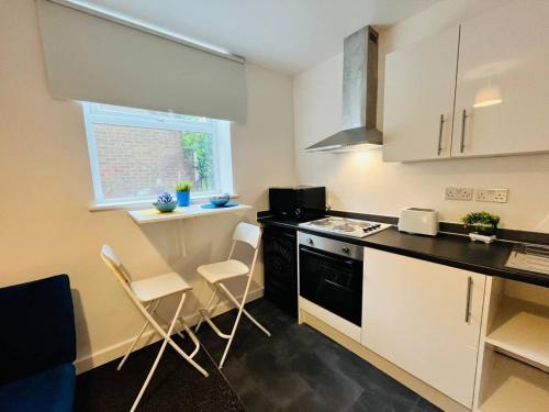a kitchen with white cabinets and a black counter top at Boutique 2Bed Apt with Great Amenities in Liverpool