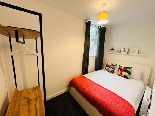 een kleine slaapkamer met een bed en een spiegel bij Boutique 2Bed Apt with Great Amenities in Liverpool