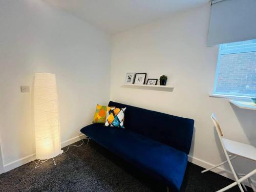 a living room with a blue couch and a window at Boutique 2Bed Apt with Great Amenities in Liverpool