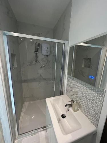 a white bathroom with a shower and a sink at Guest Suite in Glenageary in Dublin