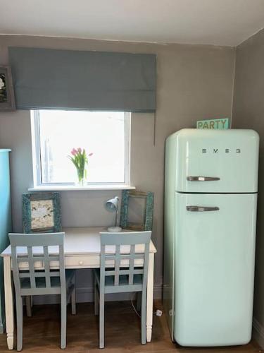 a kitchen with a table and a refrigerator and chairs at Guest Suite in Glenageary in Dublin