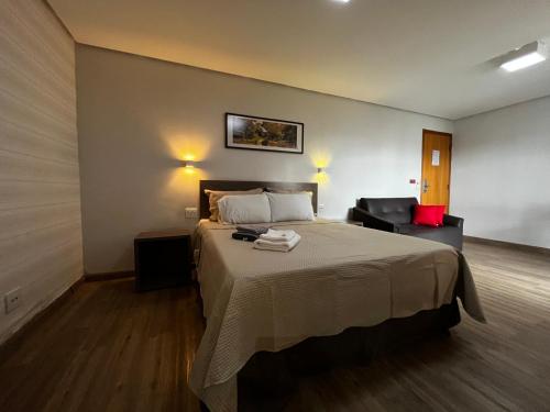Habitación de hotel con cama y silla en Flat 1209 - Conforto Parque Areião, en Goiânia