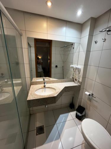 y baño con lavabo y espejo. en Flat 1209 - Conforto Parque Areião, en Goiânia