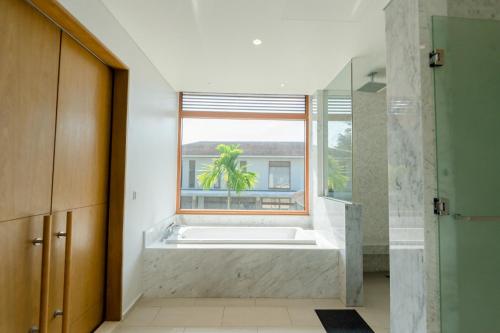 baño con bañera y ventana en Tận hưởng Biệt thự 5 phòng ngủ với hồ bơi riêng biệt en Da Nang