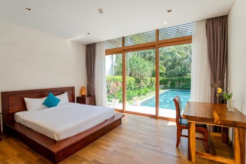 1 dormitorio con cama, mesa y escritorio en Tận hưởng Biệt thự 5 phòng ngủ với hồ bơi riêng biệt en Da Nang