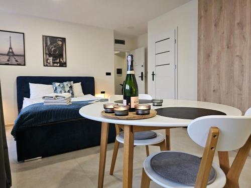 een slaapkamer met een bed en een tafel met een fles wijn bij URBAN APARTMENTS PREMIUM Baildona 18A with GARAGE in Katowice