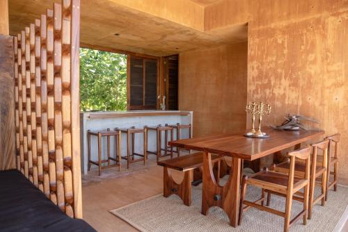 a dining room with a table and a bar at Mazul Puerto Escondido in Tlachicón