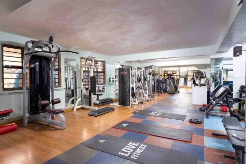 a gym with treadmills and machines in a room at Comfort plus Suite apartment in Nairobi